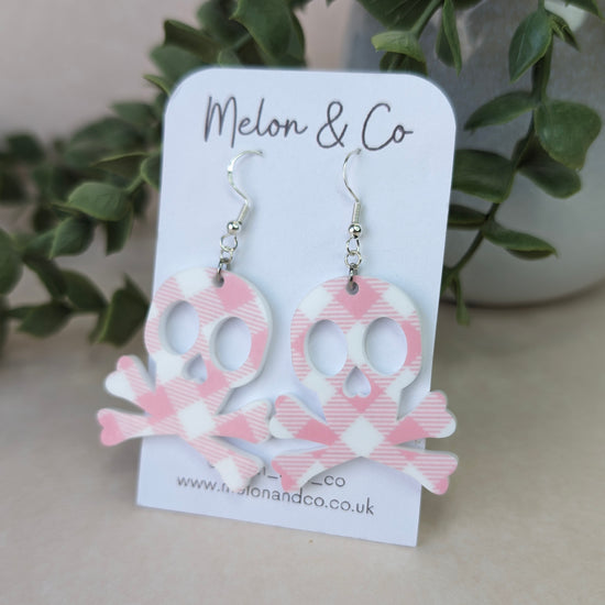 Simple skull and crossbones acrylic earrings. White and pink gingham pattern
